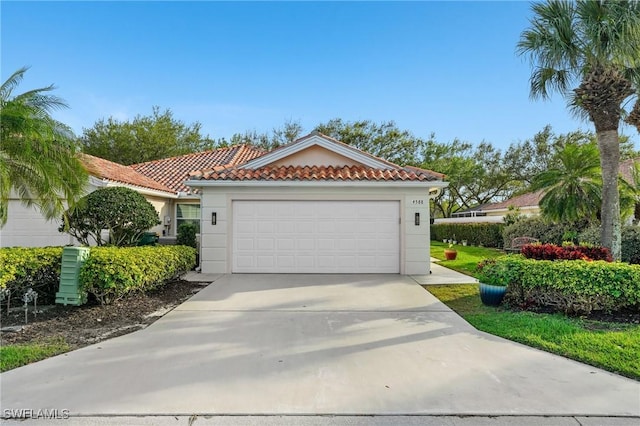 mediterranean / spanish home with concrete driveway, an attached garage, a tiled roof, and stucco siding