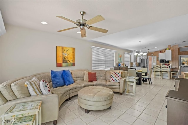 living room featuring light tile patterned floors, ceiling fan with notable chandelier, and recessed lighting