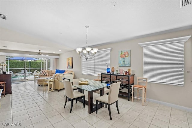 dining space with ceiling fan with notable chandelier, visible vents, baseboards, and light tile patterned floors