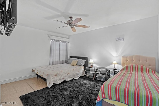 bedroom with a ceiling fan, tile patterned flooring, and baseboards