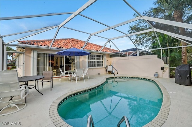 pool with glass enclosure and a patio area