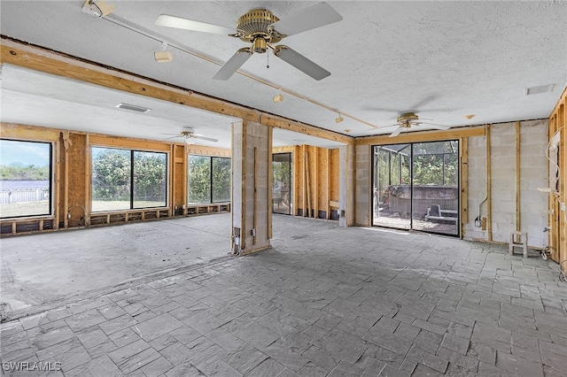 interior space with a sunroom, visible vents, and a textured ceiling