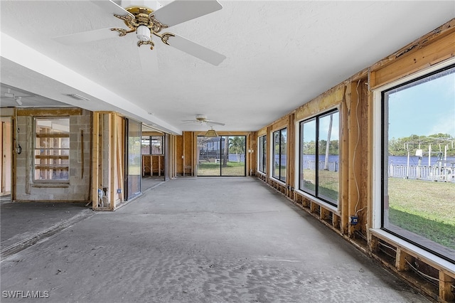 unfurnished sunroom with a wealth of natural light and a ceiling fan