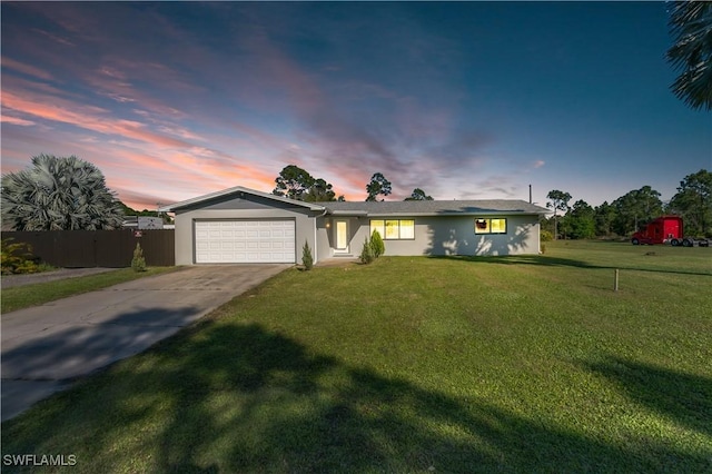 ranch-style house with an attached garage, fence, concrete driveway, stucco siding, and a front yard