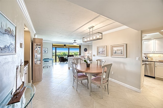 dining space with baseboards, a ceiling fan, a textured ceiling, crown molding, and light tile patterned flooring