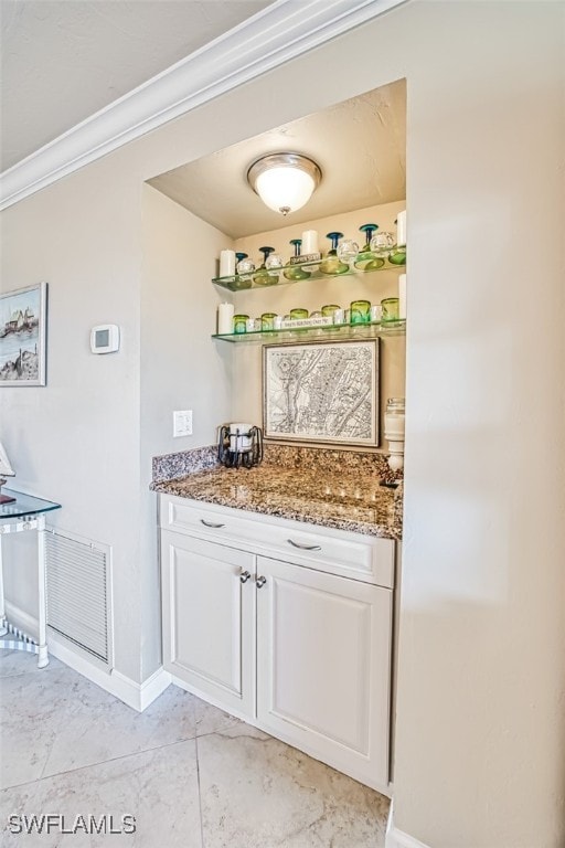 bar featuring baseboards, visible vents, and crown molding