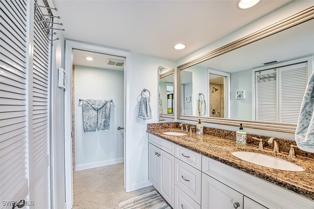 bathroom featuring a closet, a sink, visible vents, and baseboards