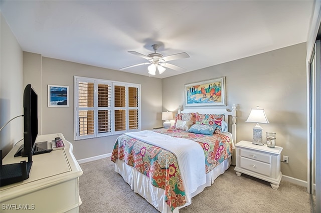 bedroom with light colored carpet, ceiling fan, and baseboards