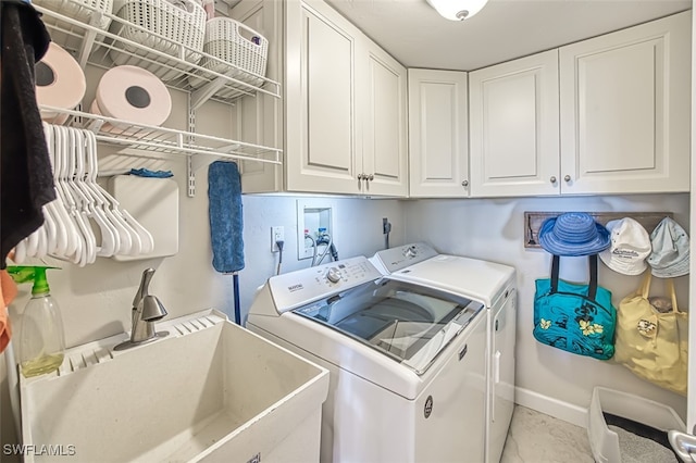 laundry area featuring cabinet space, baseboards, a sink, and washing machine and clothes dryer