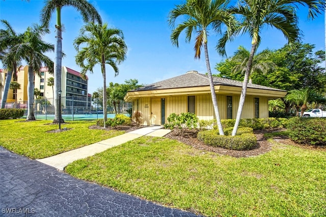 view of front of property featuring fence and a front lawn