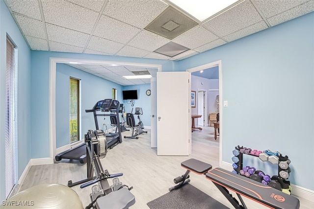 exercise area with baseboards, a drop ceiling, and wood finished floors