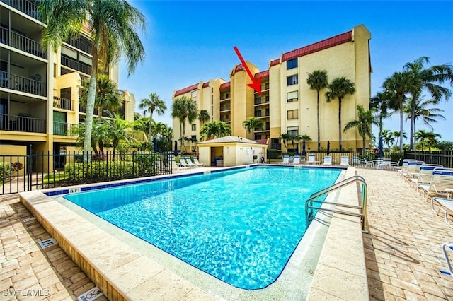 community pool featuring a patio area and fence