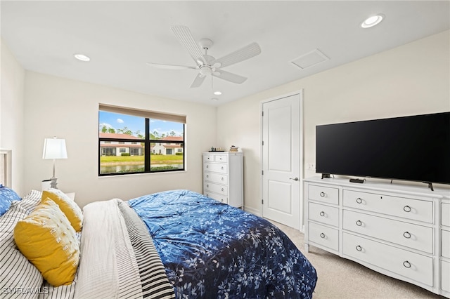 bedroom with light carpet, ceiling fan, attic access, and recessed lighting