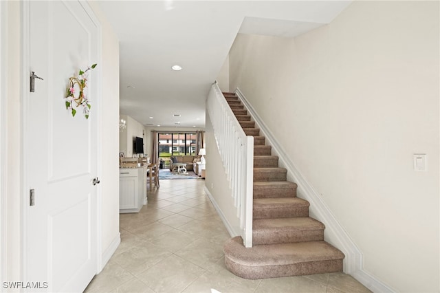 staircase featuring tile patterned flooring, baseboards, and recessed lighting