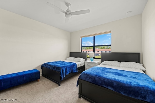 bedroom featuring light carpet and a ceiling fan