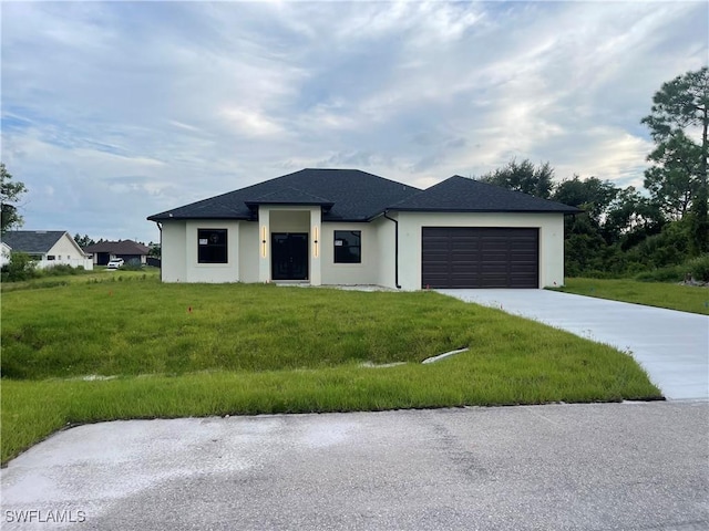 view of front of property featuring a garage, driveway, and a front yard