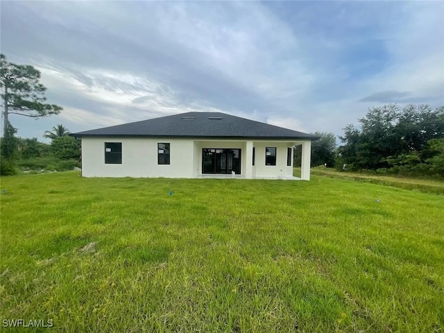 rear view of property with a lawn