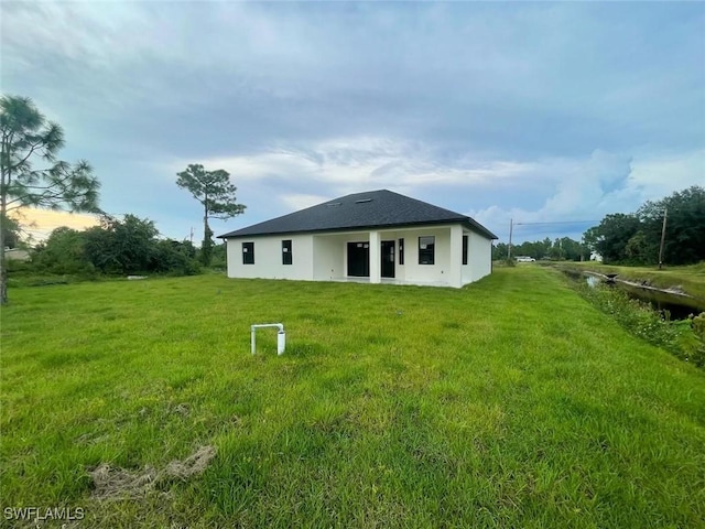 back of house featuring a lawn