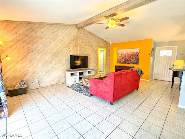 living area featuring baseboards, wooden walls, lofted ceiling with beams, and light tile patterned floors