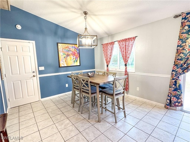 dining space with an inviting chandelier, light tile patterned floors, baseboards, and a textured ceiling