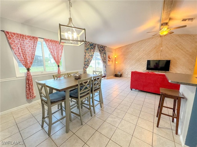 dining room with light tile patterned floors, baseboards, visible vents, and vaulted ceiling