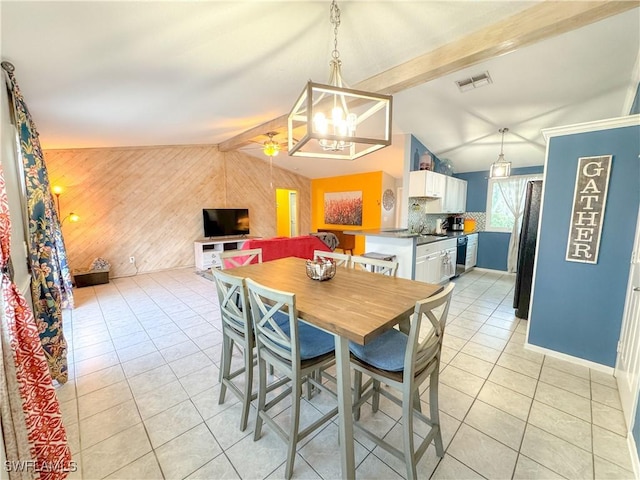 dining space featuring lofted ceiling with beams, light tile patterned floors, wood walls, visible vents, and baseboards