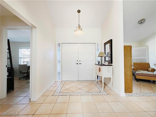 entryway featuring light tile patterned flooring and baseboards