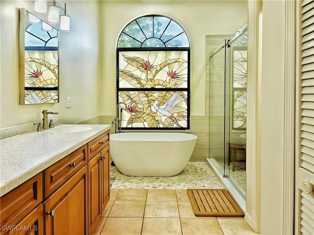 bathroom with a freestanding tub, a stall shower, tile patterned flooring, and vanity