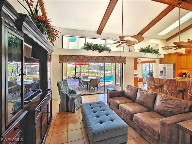 living area with high vaulted ceiling, beam ceiling, ceiling fan, and light tile patterned floors