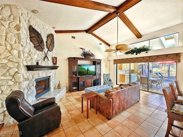 living room with light tile patterned floors, visible vents, a stone fireplace, high vaulted ceiling, and beam ceiling