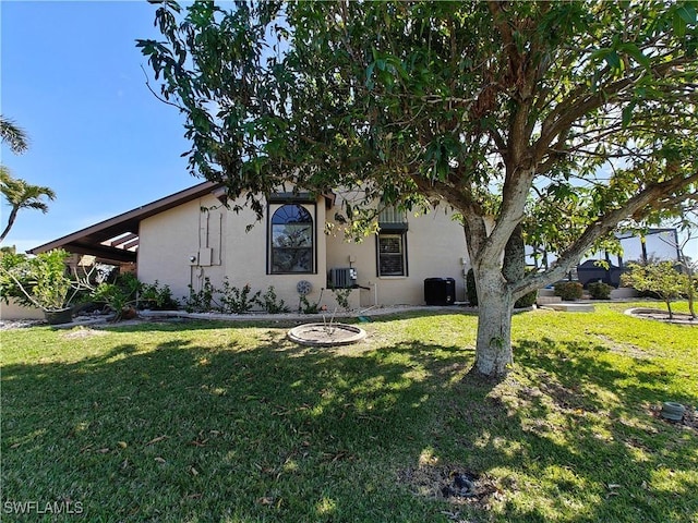 view of front of home featuring a front lawn, cooling unit, and stucco siding