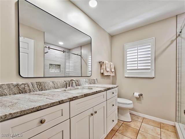 bathroom featuring toilet, a shower stall, vanity, and tile patterned floors