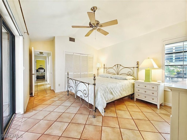 bedroom with visible vents, lofted ceiling, ceiling fan, a closet, and light tile patterned flooring