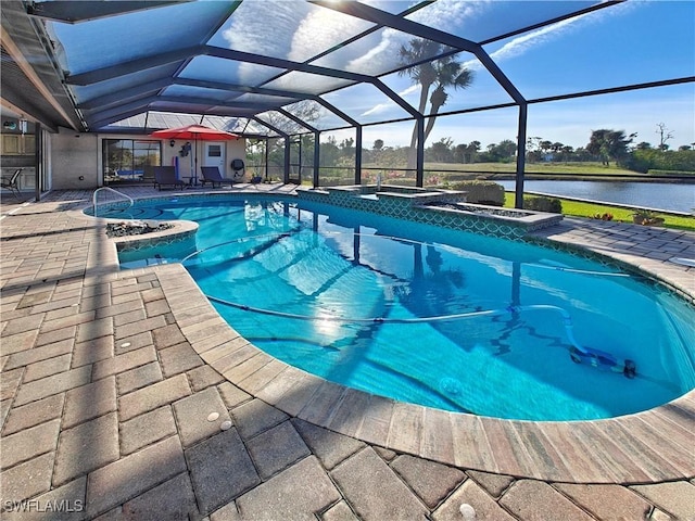 pool with a lanai, a water view, a patio, and an in ground hot tub