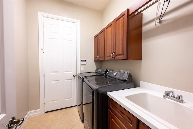 laundry room with washing machine and dryer, cabinet space, a sink, and light tile patterned floors