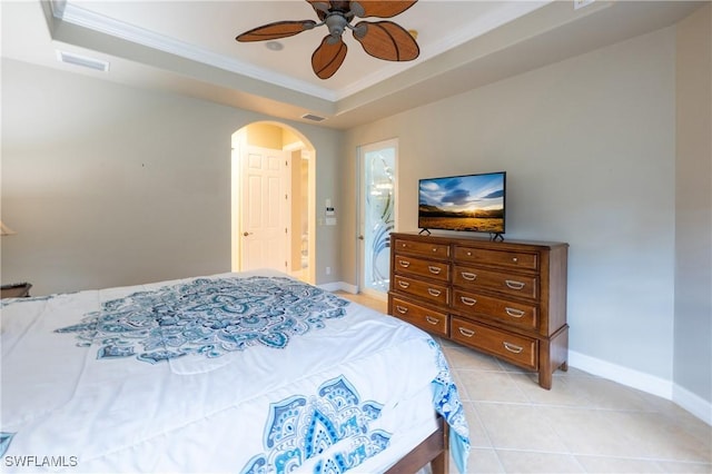 bedroom with arched walkways, light tile patterned floors, visible vents, baseboards, and a tray ceiling