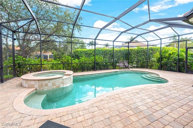 view of swimming pool featuring glass enclosure, a pool with connected hot tub, and a patio area