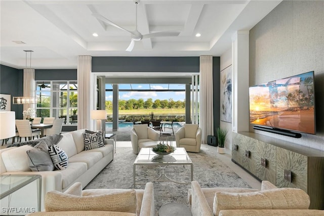 living room with ceiling fan, a raised ceiling, and recessed lighting