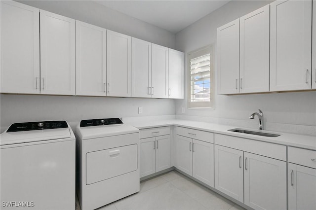 laundry room featuring cabinet space, a sink, washing machine and clothes dryer, and light tile patterned floors