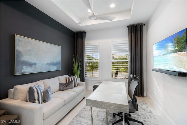 office area with a ceiling fan, recessed lighting, a raised ceiling, and baseboards