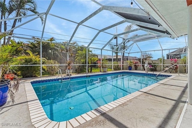 pool with a patio area and glass enclosure