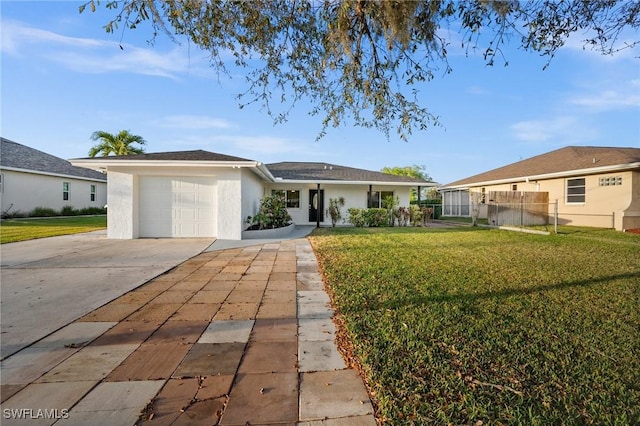 ranch-style house with a garage, fence, driveway, stucco siding, and a front lawn