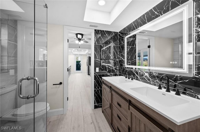 bathroom featuring toilet, tile walls, visible vents, and a sink