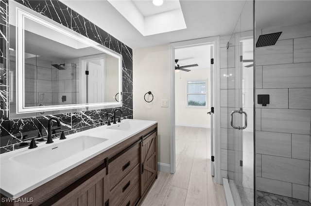 full bath with a stall shower, a sink, and backsplash