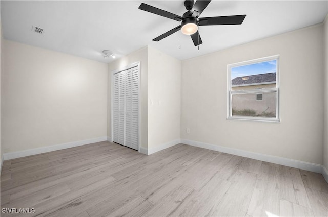 empty room featuring visible vents, ceiling fan, baseboards, and wood finished floors