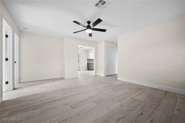 spare room with light wood-style floors, visible vents, baseboards, and a ceiling fan