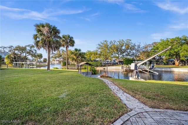 view of property's community with a water view, a dock, and a lawn