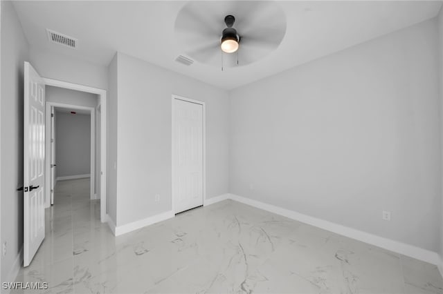 unfurnished bedroom with visible vents, baseboards, marble finish floor, and a closet