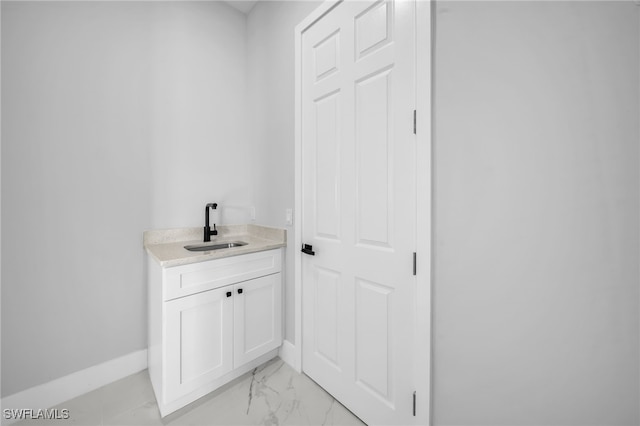 bathroom featuring baseboards, marble finish floor, and vanity