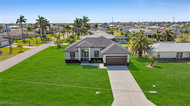 view of front facade featuring a residential view, a front yard, roof with shingles, and driveway